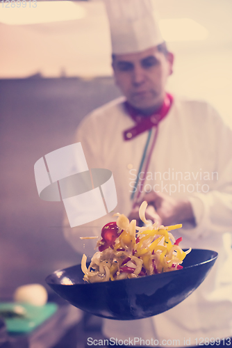 Image of chef flipping vegetables in wok
