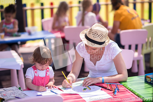 Image of mom and little daughter drawing a colorful pictures