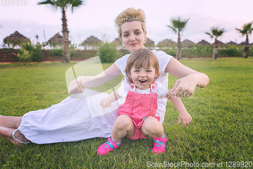 Image of mother and little daughter playing at backyard