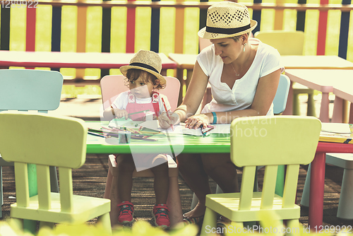 Image of mom and little daughter drawing a colorful pictures