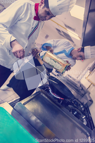 Image of chef preparing food, frying in wok pan