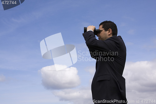 Image of Businessman looking through binoculars