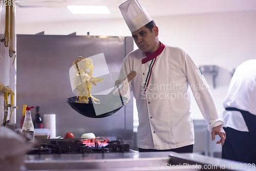 Image of chef flipping vegetables in wok