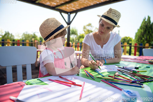 Image of mom and little daughter drawing a colorful pictures