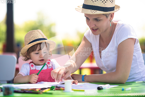 Image of mom and little daughter drawing a colorful pictures