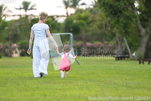 Image of mother and little daughter playing at backyard