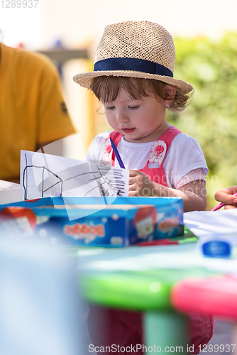 Image of little girl drawing a colorful pictures