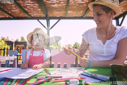 Image of mom and little daughter drawing a colorful pictures