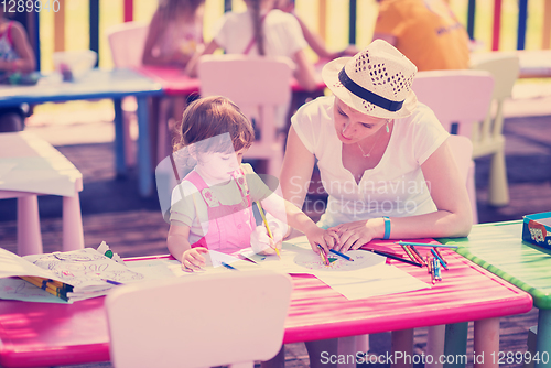 Image of mom and little daughter drawing a colorful pictures