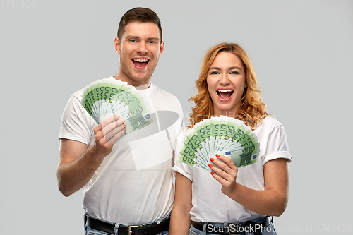 Image of happy couple in white t-shirts with euro money