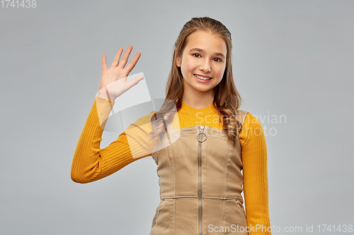 Image of happy smiling young teenage girl waving hand