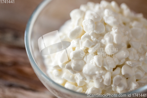 Image of close up of cottage cheese in bowl on wooden table