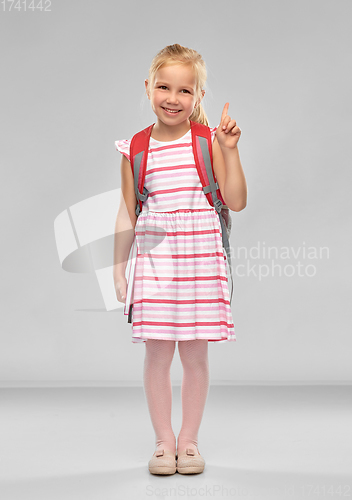 Image of little girl with school bag pointing finger up