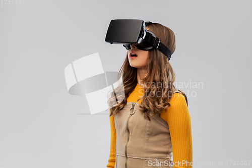 Image of teenage girl in vr glasses over grey background