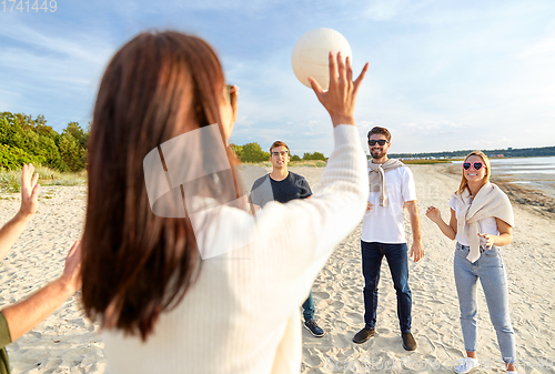 Image of friends playing volleyball on beach in summer