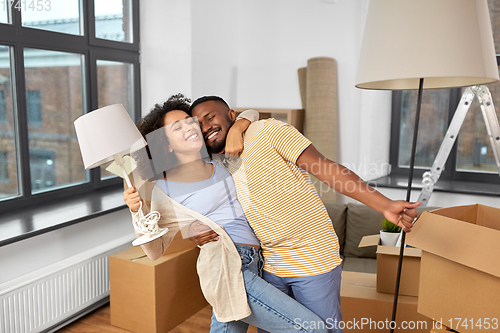 Image of happy couple packing boxes and moving to new home