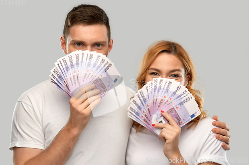 Image of happy couple in white t-shirts with euro money