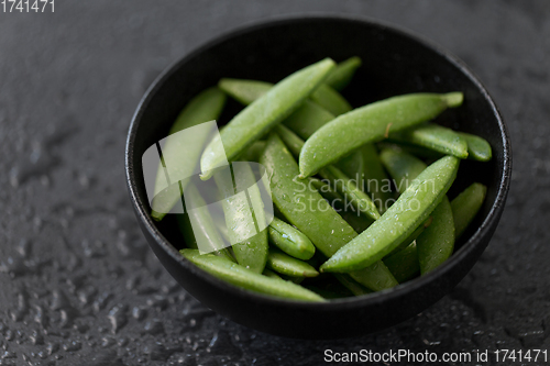 Image of peas in bowl on wet slate stone background