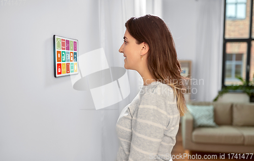 Image of woman looking at tablet computer at smart home