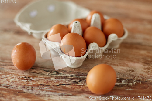 Image of close up of eggs in cardboard box on wooden table