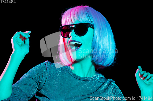 Image of happy woman in pink wig and sunglasses dancing