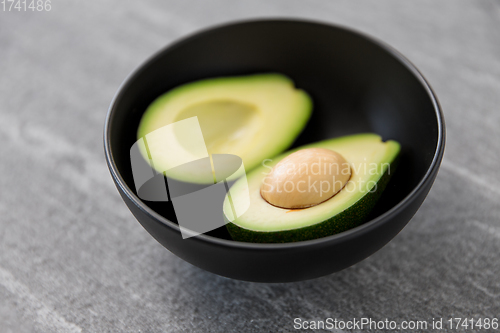 Image of close up of ripe avocado with bone in ceramic bowl