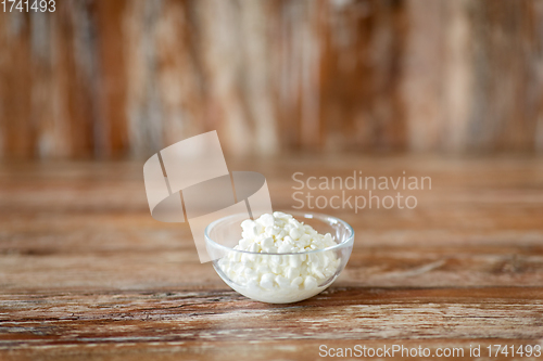 Image of close up of cottage cheese in bowl on wooden table