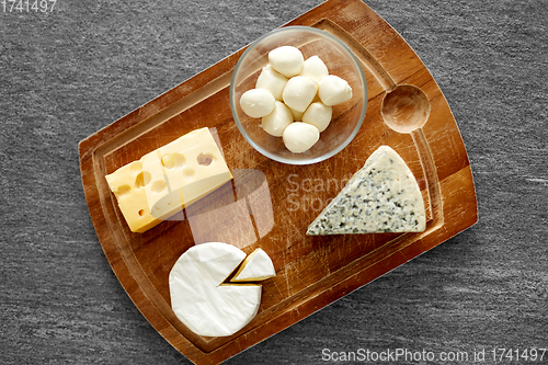 Image of different kinds of cheese on wooden cutting board