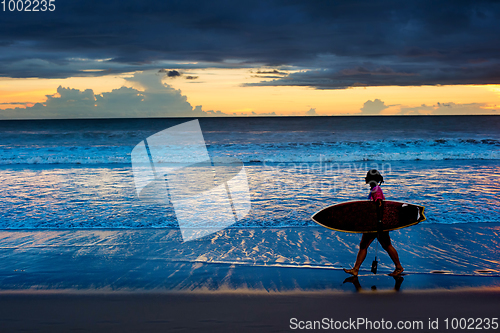 Image of Woman surfer at sunset. Bali