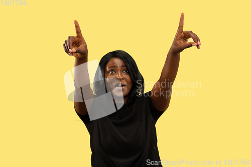 Image of Young african woman isolated on yellow studio background, facial expression