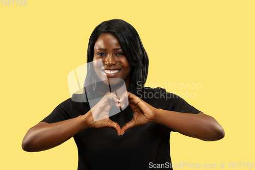 Image of Young african woman isolated on yellow studio background, facial expression