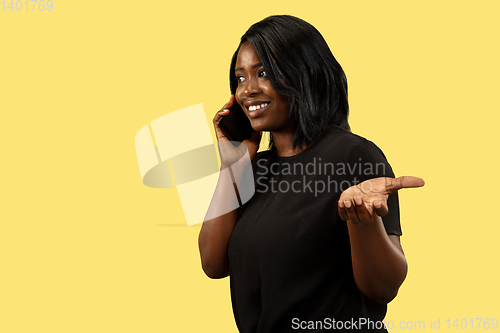 Image of Young african woman isolated on yellow studio background, facial expression