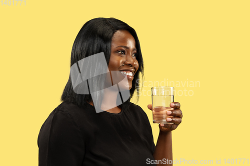 Image of Young african woman isolated on yellow studio background, facial expression