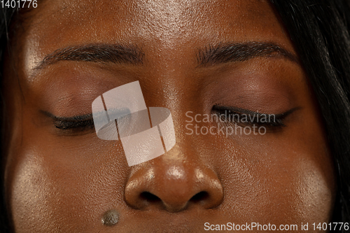 Image of Young african woman isolated on yellow studio background, facial expression