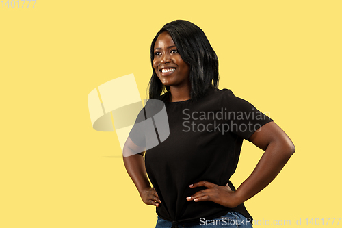 Image of Young african woman isolated on yellow studio background, facial expression