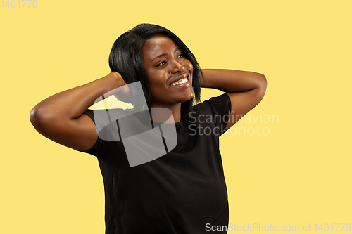 Image of Young african woman isolated on yellow studio background, facial expression