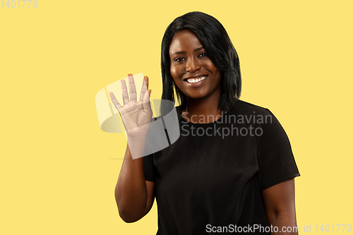 Image of Young african woman isolated on yellow studio background, facial expression