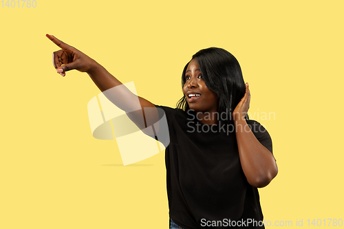 Image of Young african woman isolated on yellow studio background, facial expression