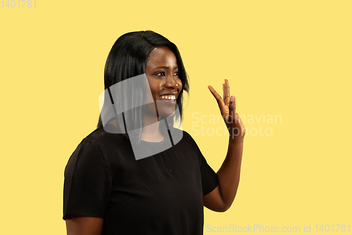 Image of Young african woman isolated on yellow studio background, facial expression