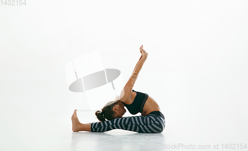 Image of Sporty young woman doing yoga practice isolated on white background