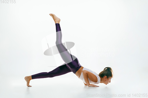 Image of Sporty young woman doing yoga practice isolated on white background