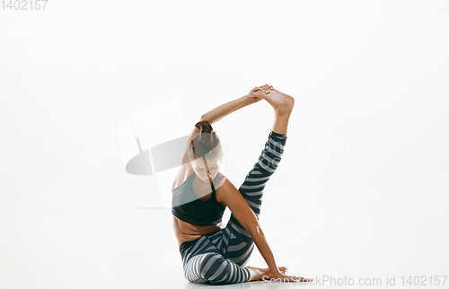 Image of Sporty young woman doing yoga practice isolated on white background