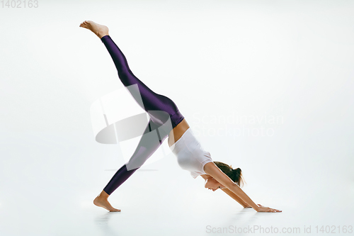Image of Sporty young woman doing yoga practice isolated on white background