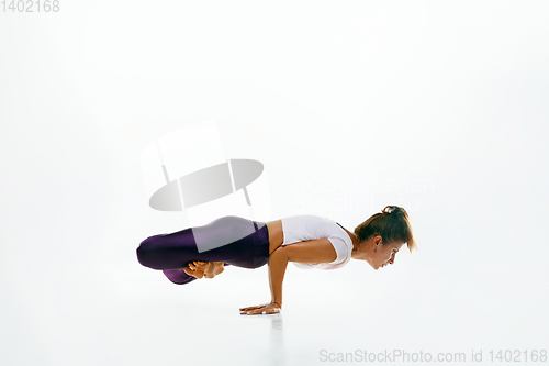 Image of Sporty young woman doing yoga practice isolated on white background