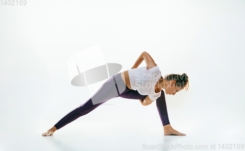 Image of Sporty young woman doing yoga practice isolated on white background