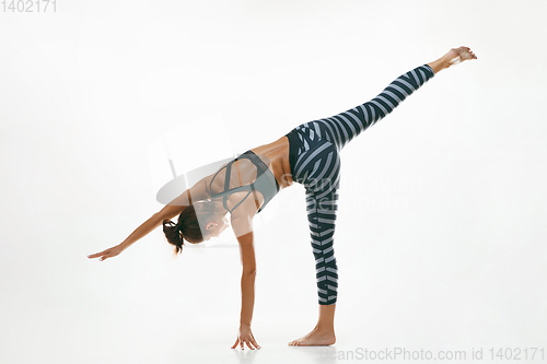 Image of Sporty young woman doing yoga practice isolated on white background