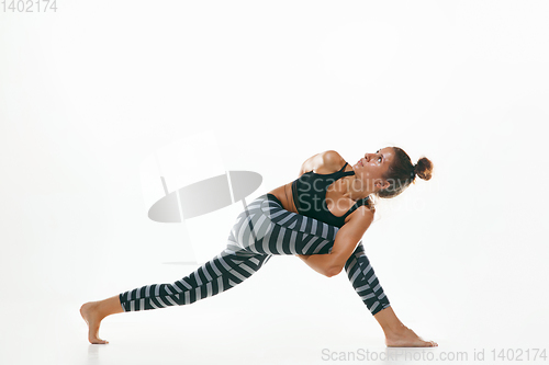 Image of Sporty young woman doing yoga practice isolated on white background