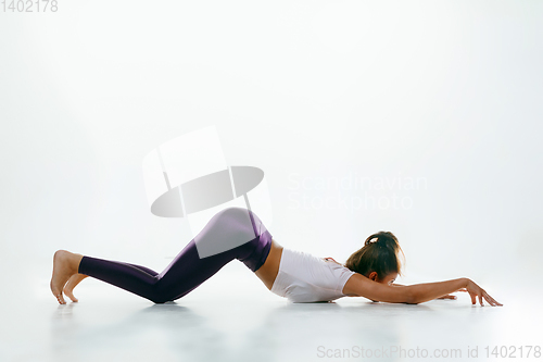 Image of Sporty young woman doing yoga practice isolated on white background