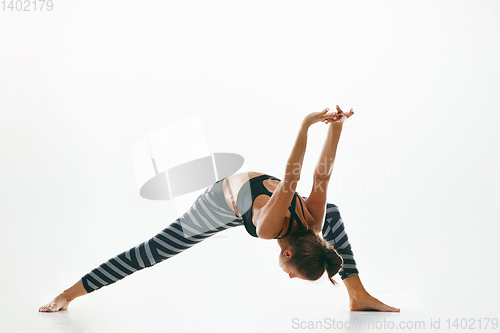 Image of Sporty young woman doing yoga practice isolated on white background