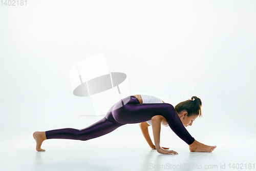 Image of Sporty young woman doing yoga practice isolated on white background